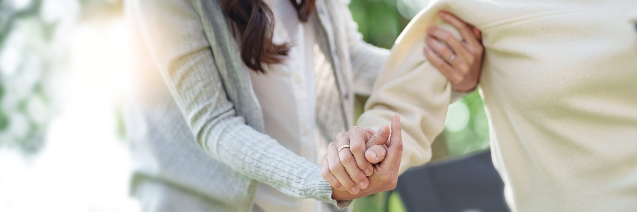 Parent and child holding hands outdoors in natural daylight
