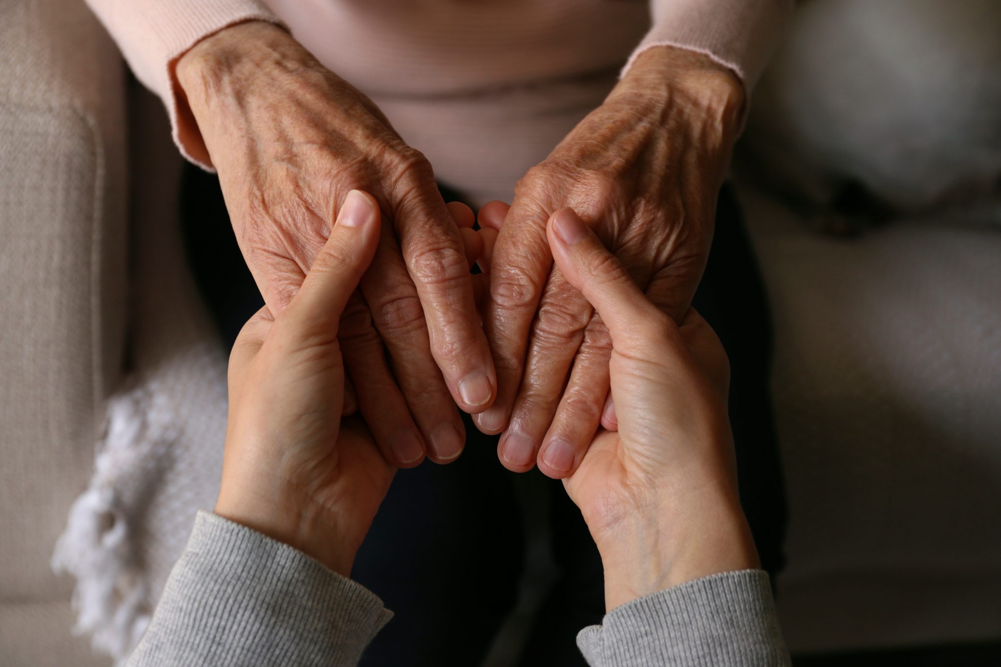 Multi-generational hands stacked together in a gesture of unity and teamwork